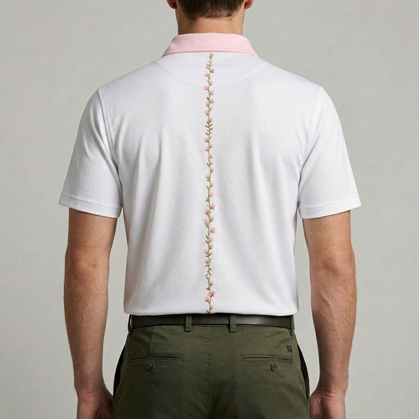 White golf polo with floral string of azaleas on his back
